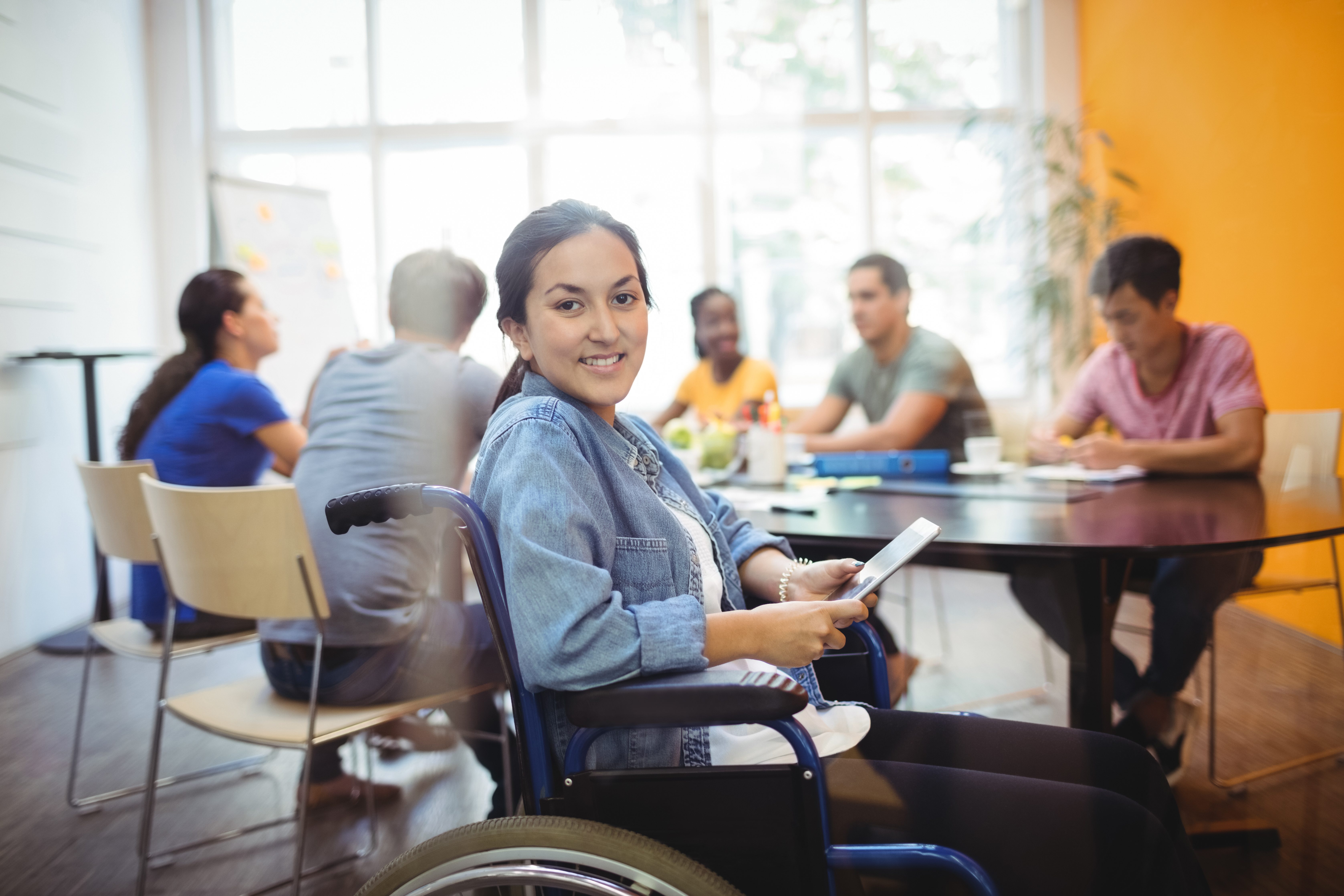 A woman in a wheelchair smiling during a business meeting